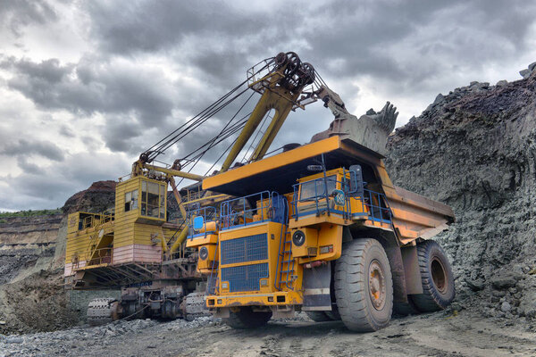 Large quarry dump truck. Loading the rock in the dumper. Loading coal into body work truck. Mining truck mining machinery, to transport coal from open-pit