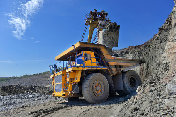 Large quarry dump truck. Loading the rock in the dumper. Loading coal into body work truck. Mining truck mining machinery, to transport coal from open-pit