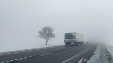 Arabalar sis. Kötü kış hava ve yolda tehlikeli otomobil trafik. Sisli gün hafif araçlar.