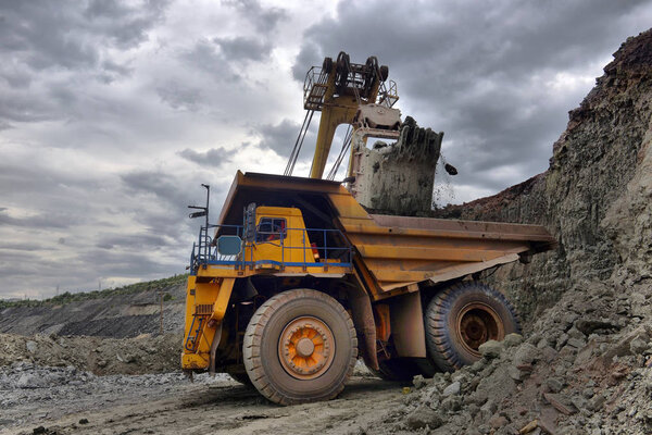 Large quarry dump truck. Loading the rock in the dumper. Loading
