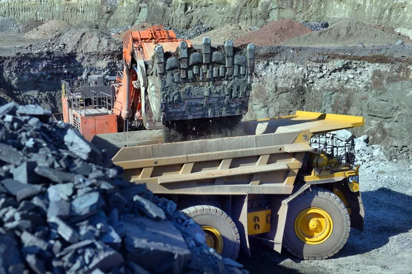 Large quarry dump truck. Loading the rock in the dumper. Loading