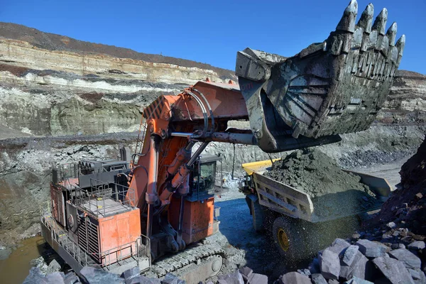 Large quarry dump truck. Loading the rock in the dumper. Loading