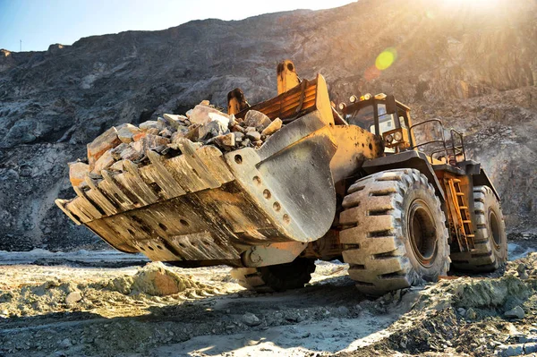 Máquina cargadora de ruedas descargando rocas en la mina abierta de hierro o —  Fotos de Stock