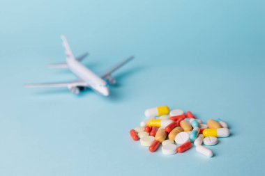 Uçak model tutması çok renkli hapları ile mavi bir arka plan üzerinde dağınık.