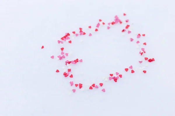 雪の中で飛び散る赤いハートのフレームです。概念のバレンタインデー。テキストのためのスペース. — ストック写真