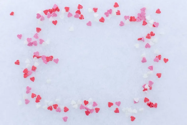 Cornice di cuori rossi sparsi nella neve. concetto giorno di San Valentino. spazio per il testo . — Foto Stock