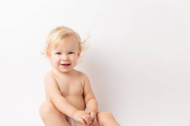 Bebek bezi bebek bebek kız beyaz bir arka plan üzerinde izole kamera bakarak mutlu gülüyor