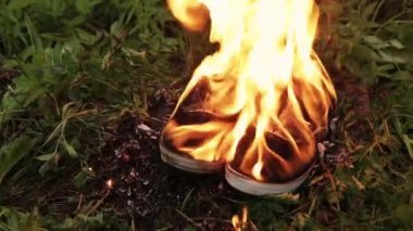 parkta çim üzerinde eski Burning botlar spor spor spor ayakkabı. ayakkabı ormanda yakmak