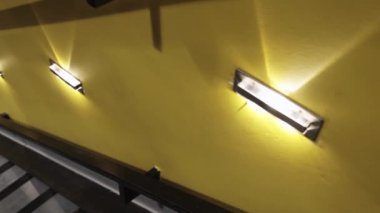 lambalar ile sarı duvarlar etrafında modern bir iç çatı merdivenlerden aşağı kamera hareketi