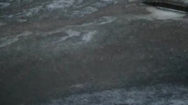 Beyaz dolu taşları bir dolu fırtınası sırasında siyah asfalt düşen