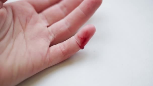 Кровь, текущая из раны на мизинце женщины крупным планом — стоковое видео