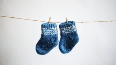 beyaz bir arka plan üzerinde clothespins ile bir ip üzerinde asılı mavi örme yünlü bebek çorap. sıcak bebek giysileri