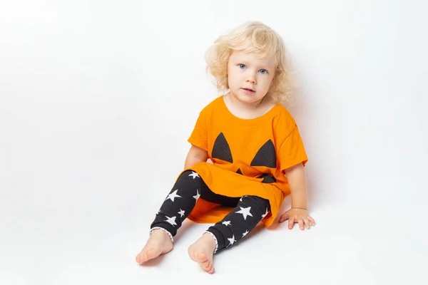 Happy Halloween. curly funny girl child in a pumpkin costume on a white background — Stock Photo, Image