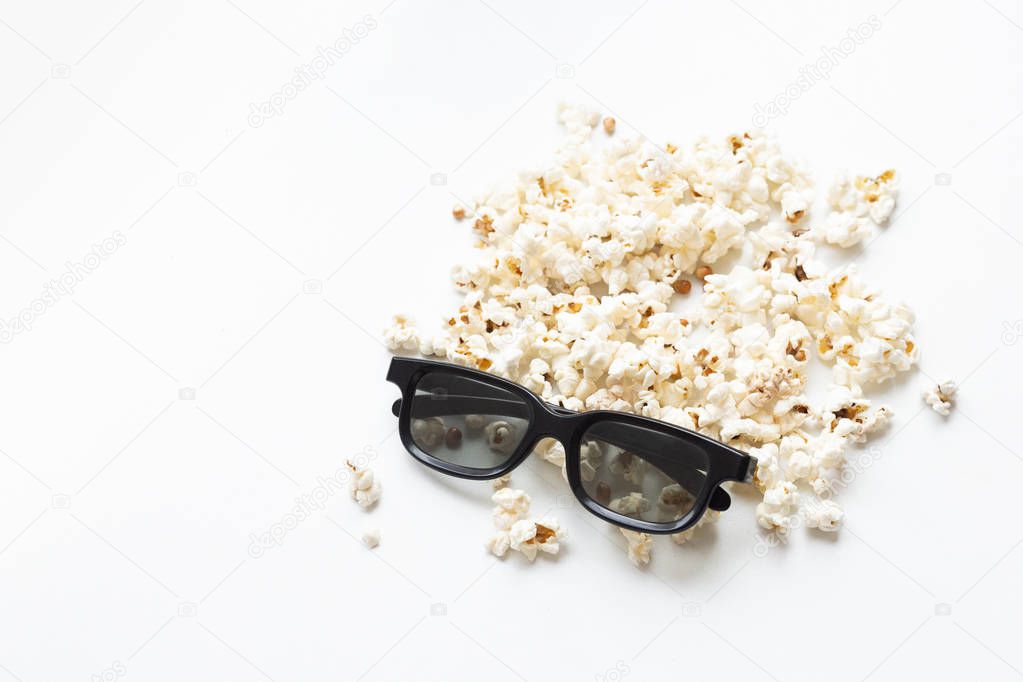 scattered popcorn and 3D glasses on white background. mock up. top view.