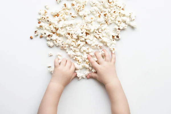 Hände Kind nehmen gesalzenes Popcorn von einem weißen Hintergrund — Stockfoto