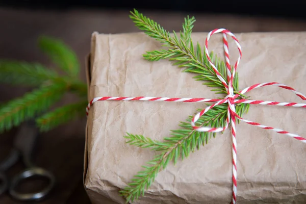 Kerstcadeaus doos presenteert op bruine houten achtergrond. kerstmis verpakt in ambachtelijk papier — Stockfoto