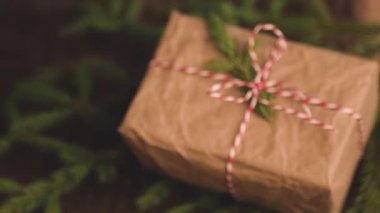 Kahverengi ahşap arka planda Noel hediyeleri kutusu. Noel hediyelerini el sanatları kağıdıyla paketliyorum.