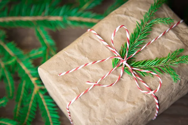 Kerstcadeaus doos presenteert op bruine houten achtergrond. kerstmis verpakt in ambachtelijk papier — Stockfoto