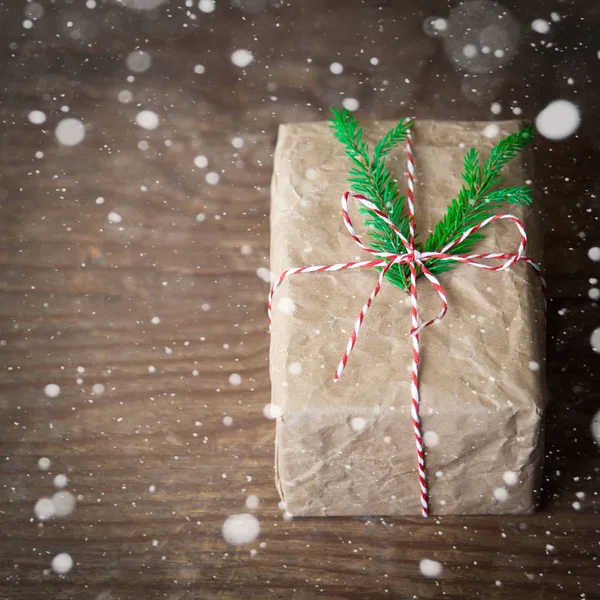 Bovenaanzicht van kleurrijke gedecoreerde ambachtelijke geschenkdoos op een retro houten tafel met pijnbomen en sneeuw. border design Kerst banner achtergrond met kopieerruimte in het midden — Stockfoto