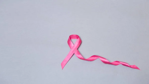 Satin ribbon sign on grey background. breast cancer concept