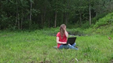  Kız parkta dizüstü bilgisayarla çalışıyor, sivrisinek dişlerini fırçalıyor.