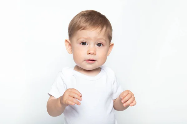 Kavkazský pěkný tmavovlasý chlapeček v bílém tričku na bílém pozadí. — Stock fotografie