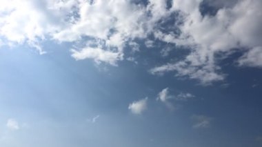 Beyaz bulut mavi gökyüzünde güneşin altında kaybolur. Kümülüs bulutlar formu parlak mavi gökyüzü karşı. Hızlandırılmış hareket bulutlar mavi gökyüzü arka plan.