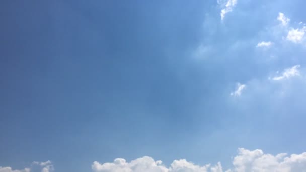 白い雲は 青い空に熱い太陽の下で消えます ループは 美しい青い空に裏打ちされた雲の時間経過の動きを備えています コマ撮り動雲青空背景と太陽 — ストック動画
