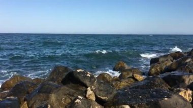 Bulutlu bir günde körfezde deniz sörf. Küçük bir fırtına. Polenca ve bağlantı noktası. Dalga deniz üzerinde büyük bir taş atıyor. Mavi gökyüzü, bulutlar ve güneş. Güneşli gün.
