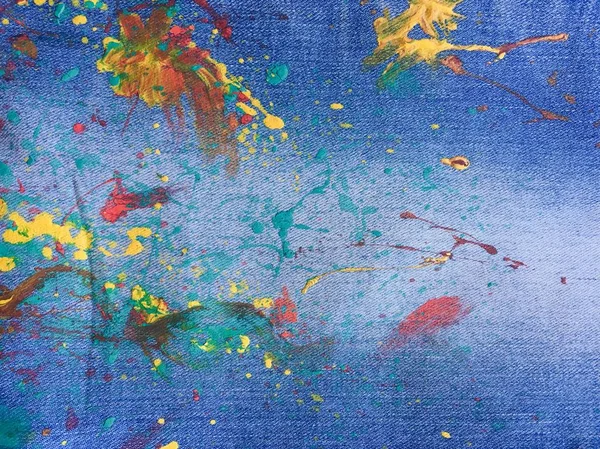 デニムやジーンズの背景にカラフルなペイントの質感 デニム ジーンズの青色の背景色塗りの滴 — ストック写真