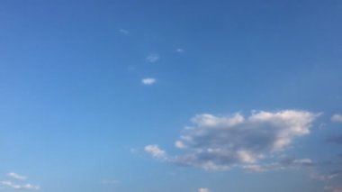 Beyaz bulutlar güneşin altında mavi gökyüzü üzerinde kaybolur. Döngü zaman atlamalı hareket bulutlar güzel bir mavi gökyüzü tarafından desteklenen özellikleri. Hızlandırılmış hareket bulutlar mavi gökyüzü arka plan ve güneş.