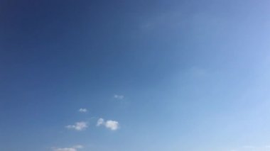 Bulutlu gökyüzü. Beyaz bulutlar güneşin altında mavi gökyüzü üzerinde kaybolur. Hızlandırılmış hareket bulutlar mavi gökyüzü arka plan. Beyaz bulutlar ve güneş mavi gökyüzü.