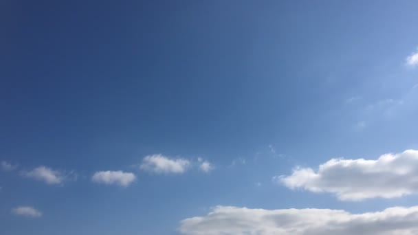 Zamračená obloha. Bílé mraky zmizí v horkém slunci na modré obloze. Time-Lapse pohybu mraky modré obloze na pozadí. Modrá obloha s bílé mraky a slunce.