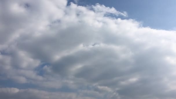 Les nuages blancs disparaissent sous le soleil chaud sur le ciel bleu. Loop dispose de nuages de mouvement de laps de temps soutenus par un beau ciel bleu. Time-lapse mouvement nuages ciel bleu fond et soleil .