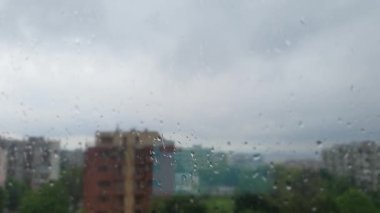 Pencereden süzülen fırtınalı yağmur damlaları
