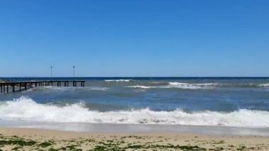 Deniz doğumu ve dalgalanma dalgaları. Altın sabah gökyüzü ve kumsalda rahat bir atmosfer.