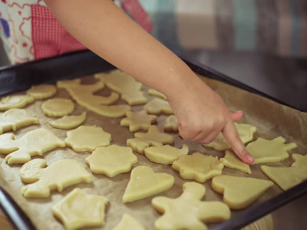 A child at home cuts out cookie cutters. Stock Image