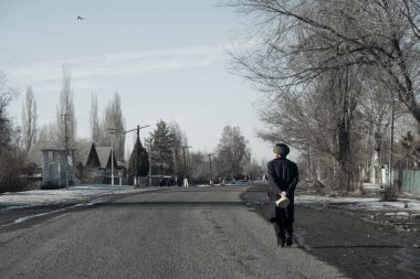 Kırgız dedesi köydeki yol boyunca yürür ve ekmek taşır