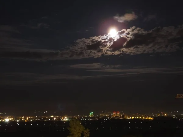 Město v noci se měsíc na obloze — Stock fotografie