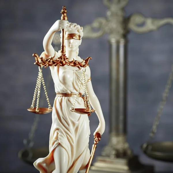sculpture of blind Themis holding empty balance scales, mythological Greek goddess, symbol of justice