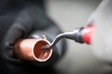 Oyma aleti ve metalik boru ile çalışan adam