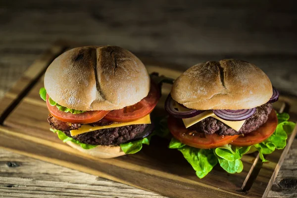 Dwa Świeże Pyszne Cheeseburgery Płyty Drewniane Szybkie Jedzenie Koncepcja — Zdjęcie stockowe