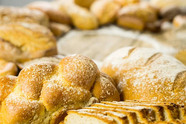 小麦粉の木製テーブルの上のパンのおいしいパン各種 — ストック写真