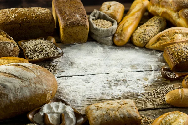 Různé Chutné Bochníky Chleba Dřevěný Stůl Moukou — Stock fotografie