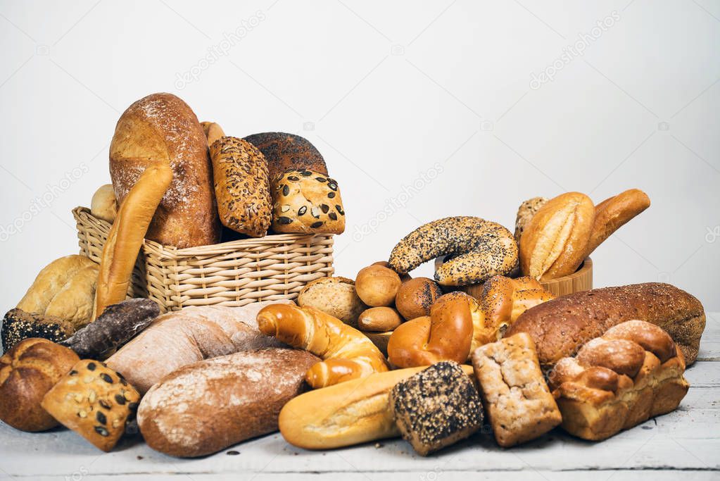 variety of delicious loaves of bread on wooden table 