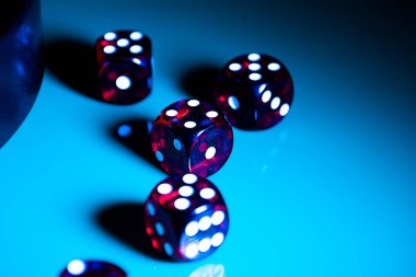 Colorful game dice with dots on blurred background clipart