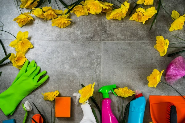 Home cleaning concept. Frame of various Cleaning Products and yellow flowers, place for typography