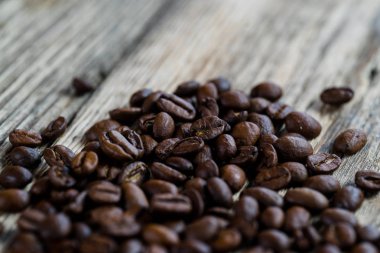 Ahşap masa üzerinde kavrulmuş kahve çekirdekleri yığını