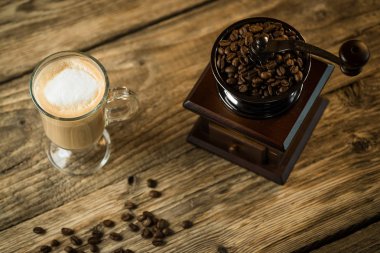 Vintage kahve öğütücü ile kavrulmuş kahve çekirdekleri ve kahve ahşap tablo