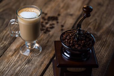 Vintage kahve öğütücü ile kavrulmuş kahve çekirdekleri ve kahve ahşap tablo